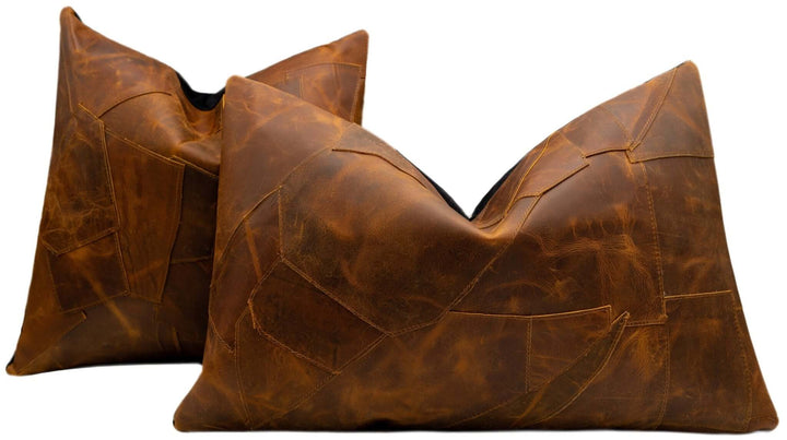 Two brown leather pillows on a white background