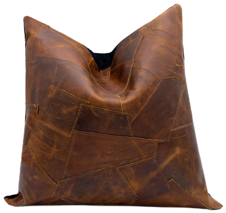 Brown leather pillow with patchwork design on a white background