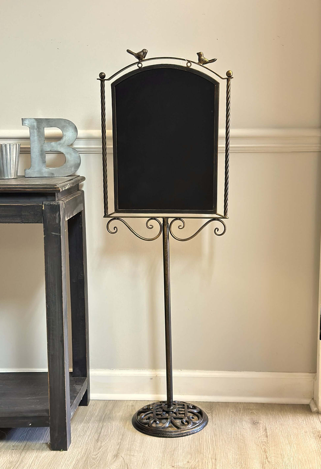 Farmhouse metal chalkboard stand with birds, featuring a rustic bronze finish and twisted rod frame, perfect for cozy kitchen decor.