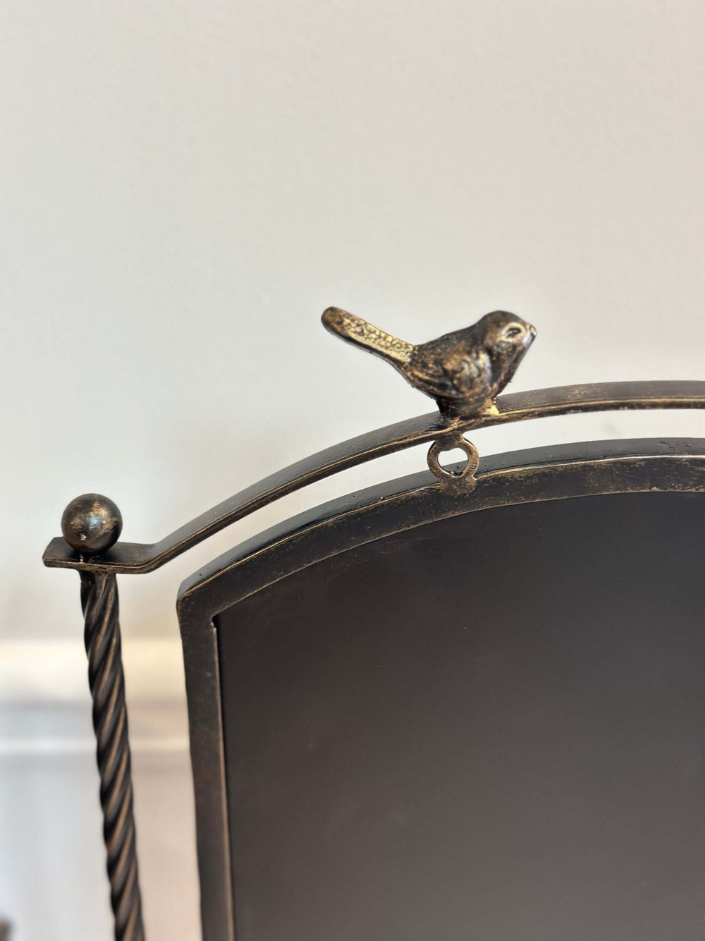 Farmhouse metal chalkboard stand with bird accent, rustic bronze finish, featuring twisted rods and a matte black board.