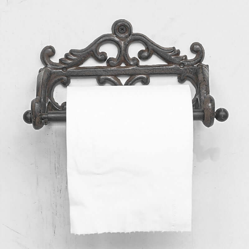 Decorative metal toilet paper holder with a roll of toilet paper on a white background