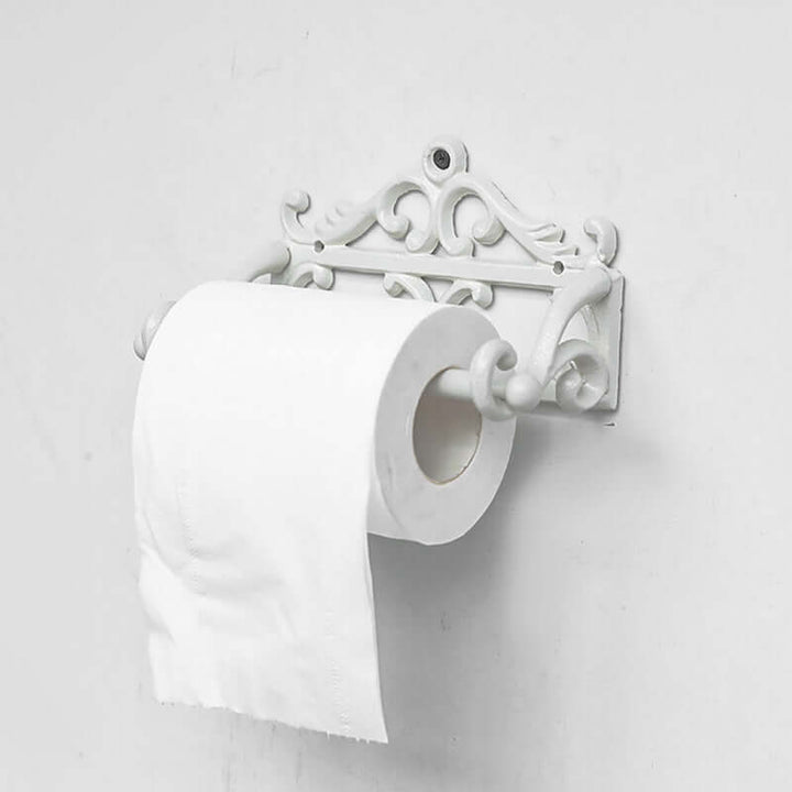Decorative white toilet paper holder with two rolls of toilet paper on a light gray background