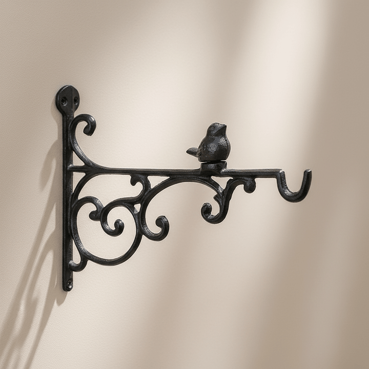 Decorative black metal wall hook with bird design on a beige background