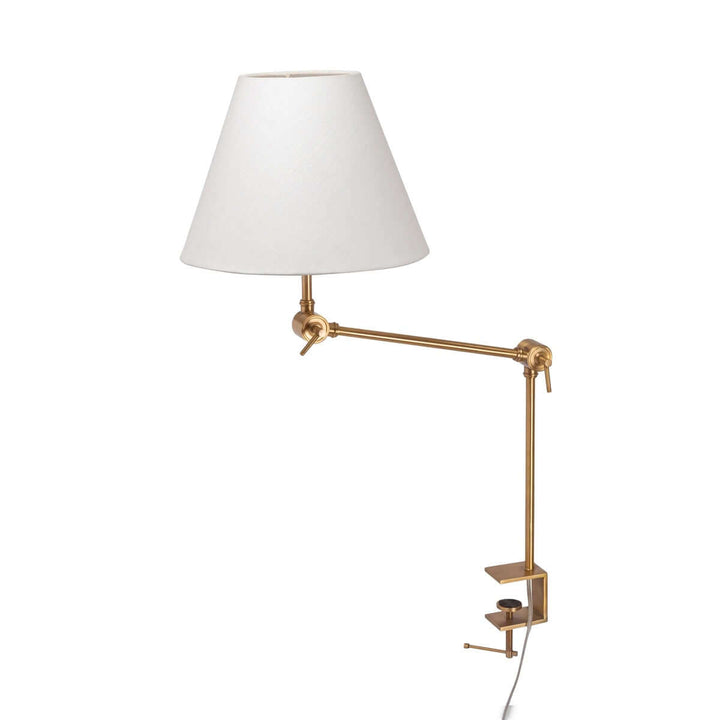 Wall-mounted lamp with white shade and gold arm on a white background