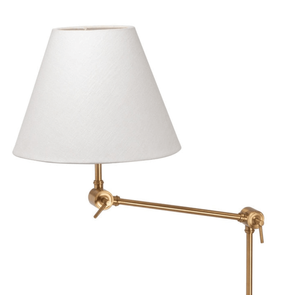 Wall-mounted lamp with white shade and gold metal arm on a white background