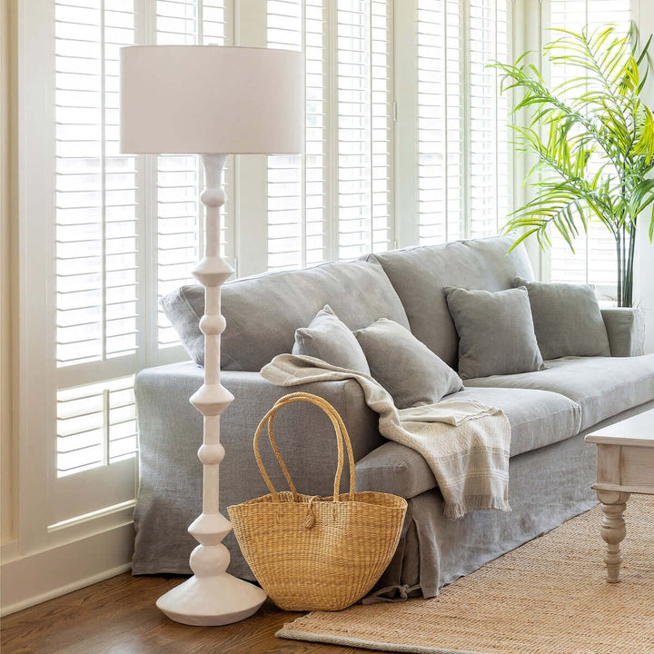 Gray sofa with a lamp and basket in a bright living room
