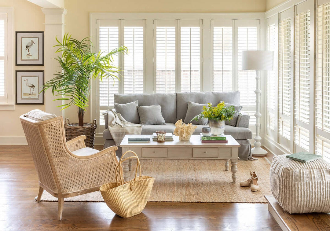 Living room with gray sofa, wicker chair, and wooden coffee table.