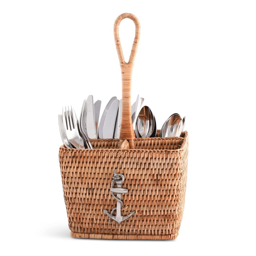 Wicker utensil holder with cutlery and a wooden spoon on a white background