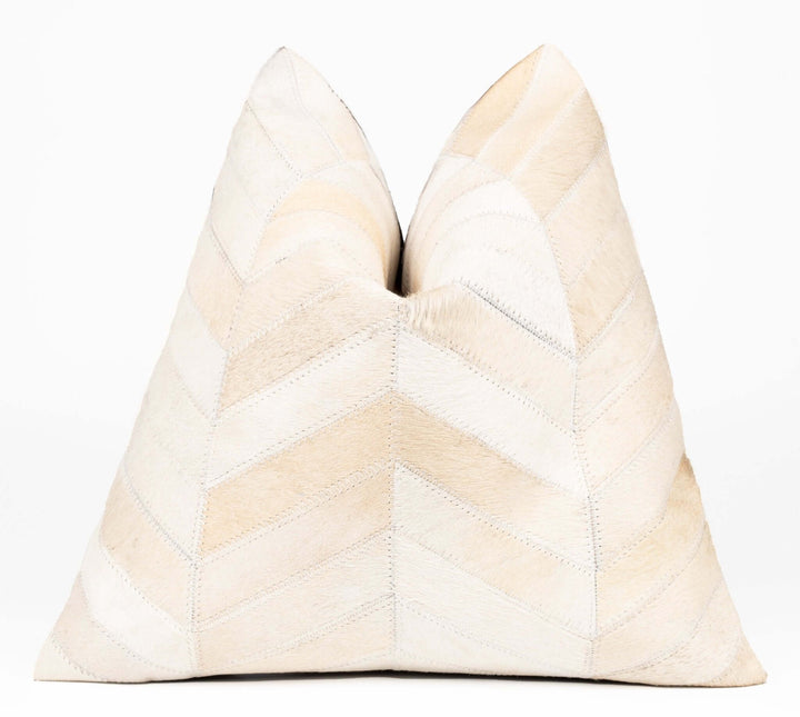 Beige pillow with a chevron pattern on a white background