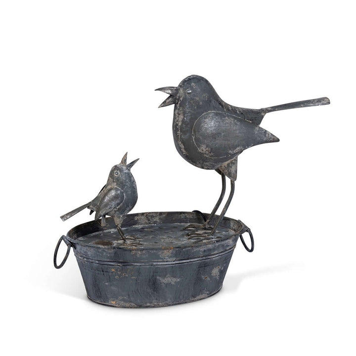 Vintage galvanized bird fountain with mother and baby bird sculpture, evokes cottage garden serenity and family togetherness.
