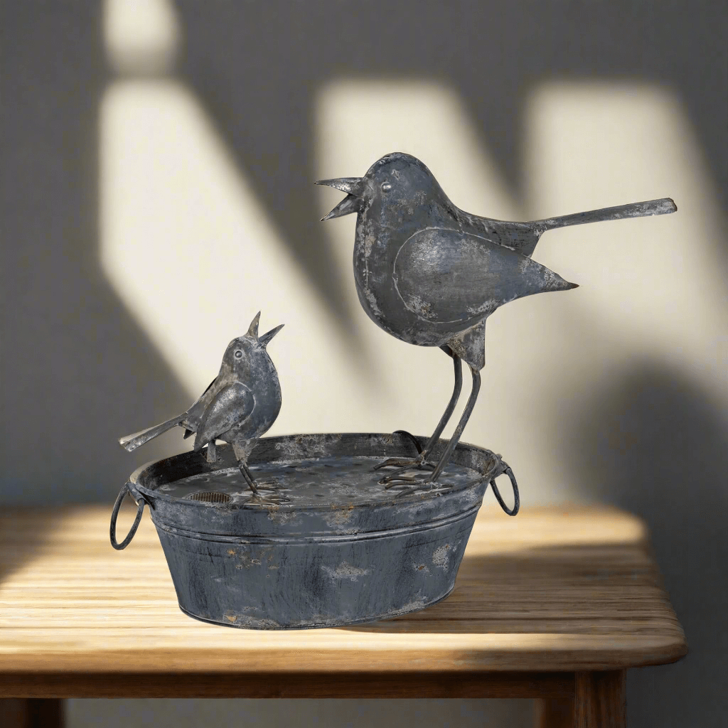 Vintage galvanized bird fountain featuring mother and baby bird, evokes cottage garden serenity and family togetherness.