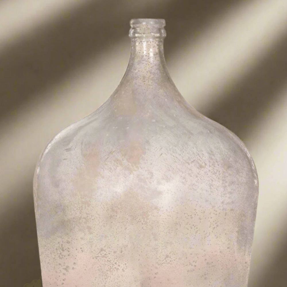 Vintage demijohn glass bottle in antique green with a rustic, old-world charm.