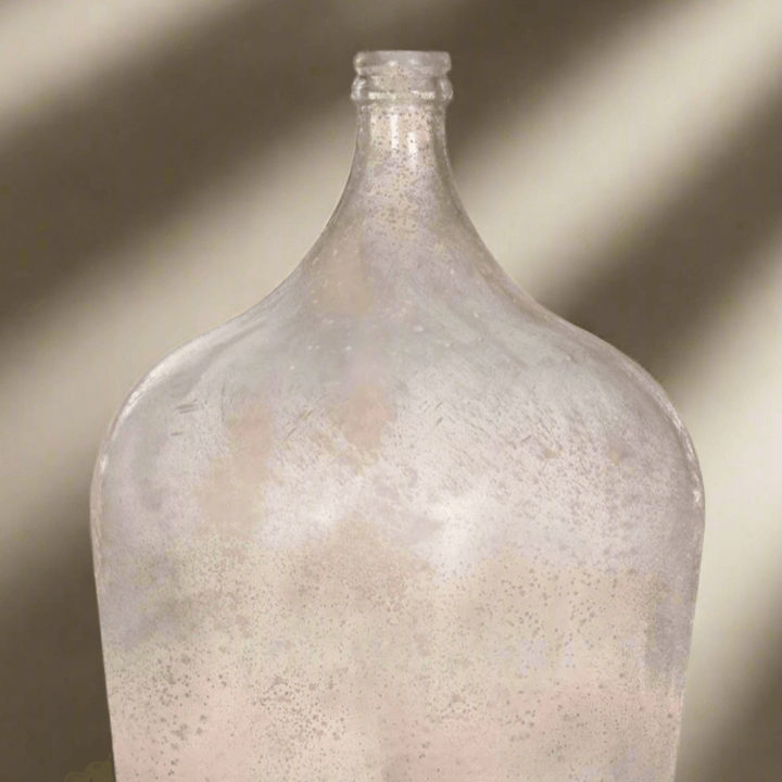Vintage demijohn glass bottle in antique green with a rustic, old-world charm.