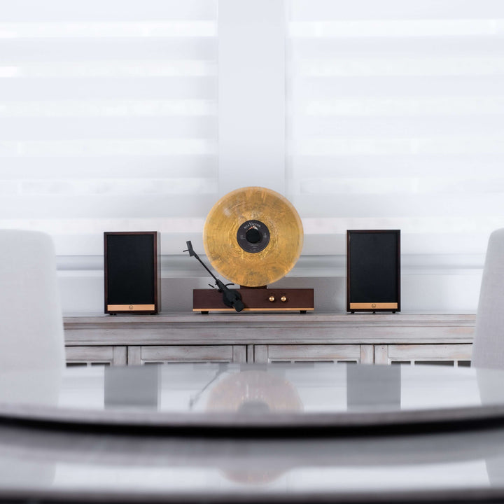 Record player with speakers on a shelf against a white wall