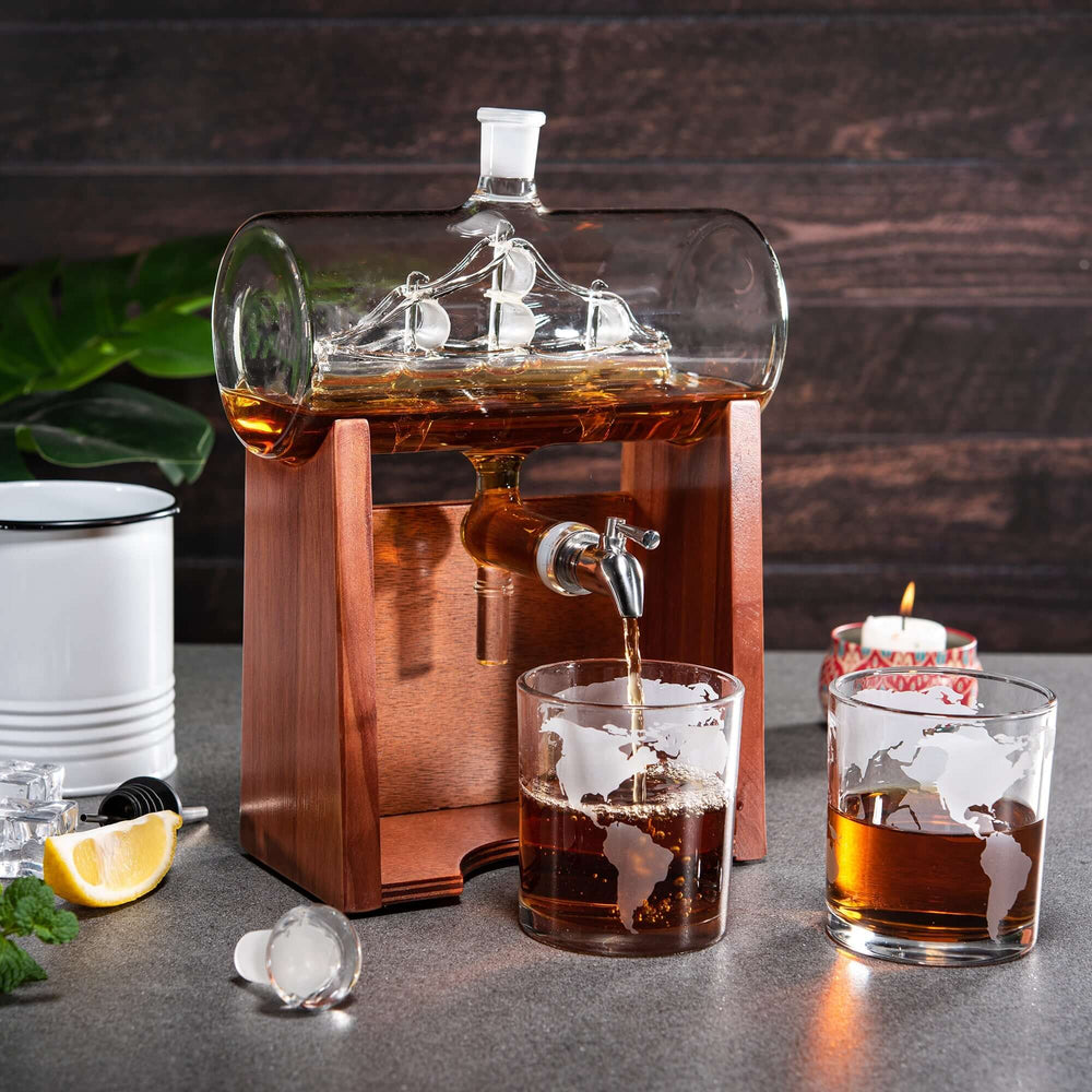 Whiskey decanter with ship design, pouring into glasses on a wooden surface.