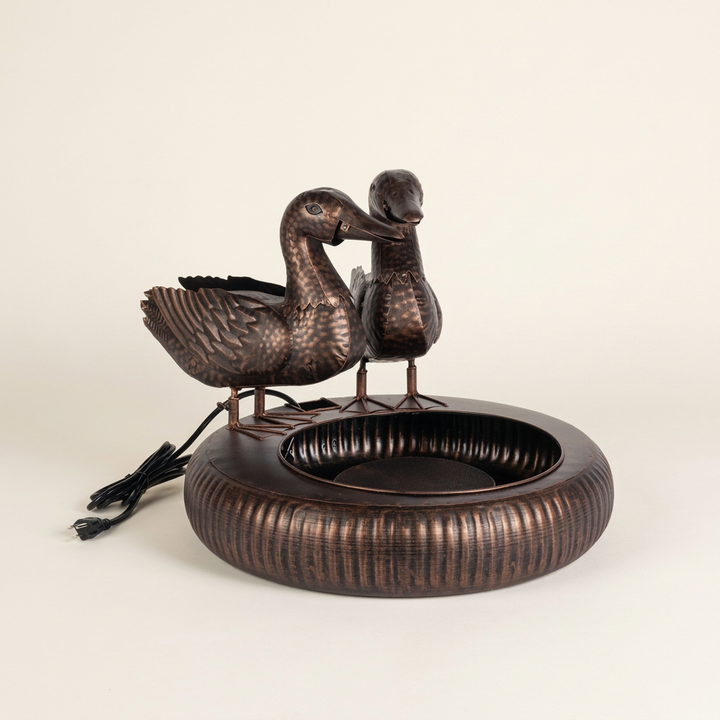 Black Bronze Dabbling Ducks Fountain on an ivory studio background, showing two upright ducks, a ribbed basin, and power cord.
