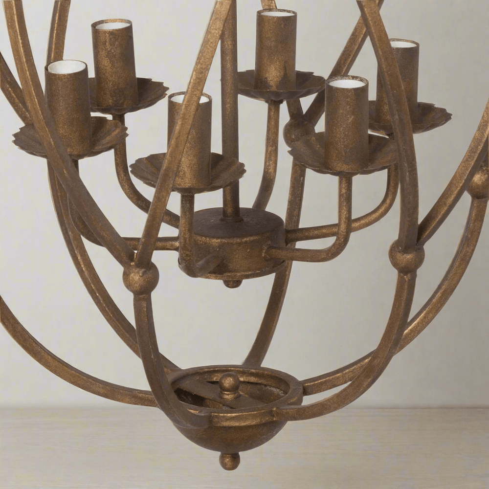 Bronze chandelier with multiple light holders on a plain background