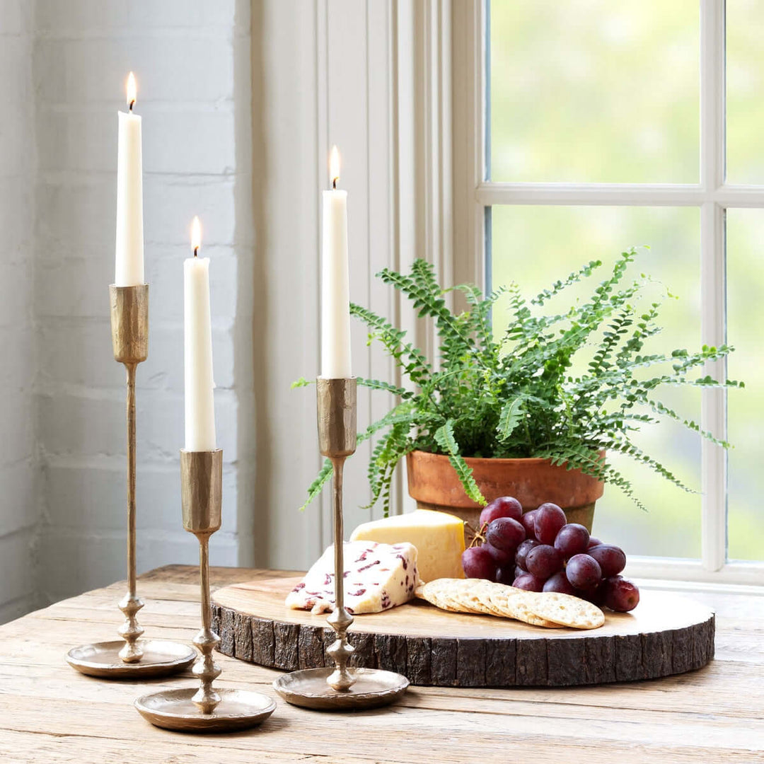 Vintage Antique Gold Iron Taper Candle Holders Set on a table with grapes and cheese, evoking colonial dining room elegance.