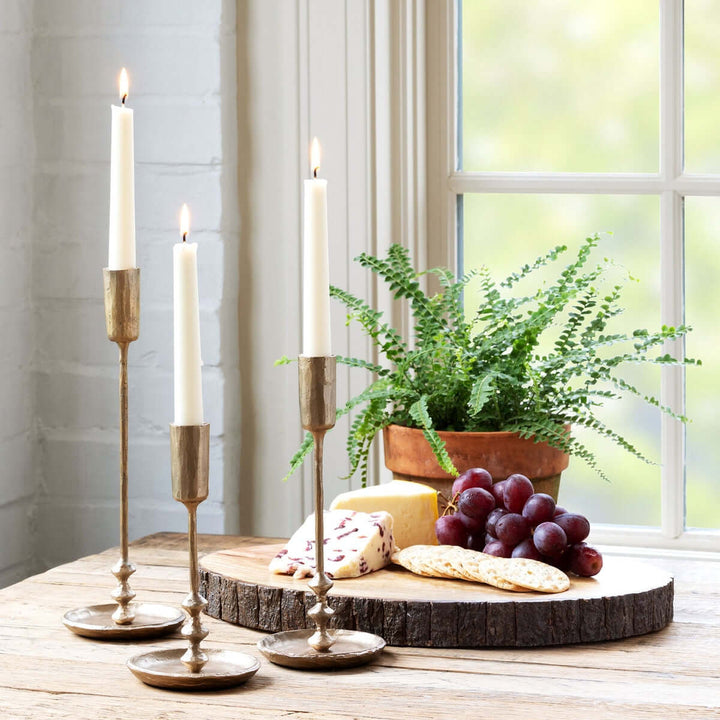 Vintage Antique Gold Iron Taper Candle Holders Set on a table with grapes and cheese, evoking colonial dining room elegance.