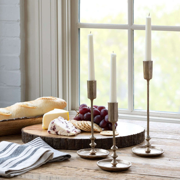 Vintage Antique Gold Iron Taper Candle Holders Set on rustic table with bread, cheese, and grapes