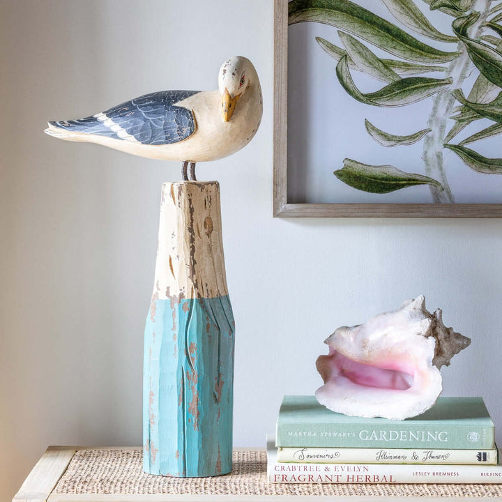 Vintage nautical seagull figurine perched on weathered wooden buoy, handcrafted in sea-washed turquoise and ivory hues, coastal decor