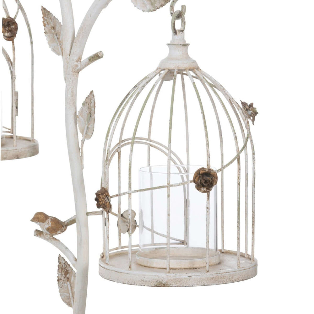 Vintage birdcage candle holder in distressed iron with antique white finish and intricate leaf details.