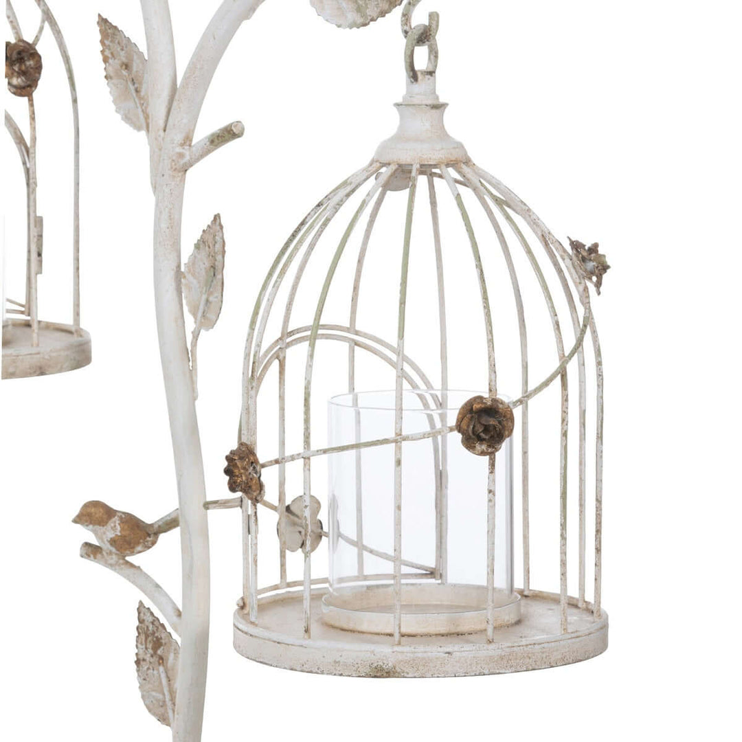 Vintage birdcage candle holder in distressed iron with antique white finish and intricate leaf details.