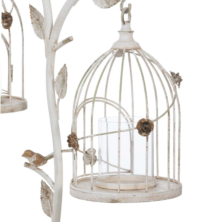 Vintage birdcage candle holder in distressed iron with antique white finish and intricate leaf details.