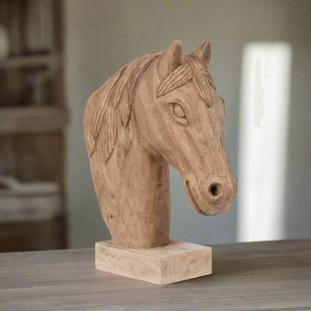 Rustic wooden horse head sculpture on table, handmade art piece for farmhouse decor emphasizing strength and grace.