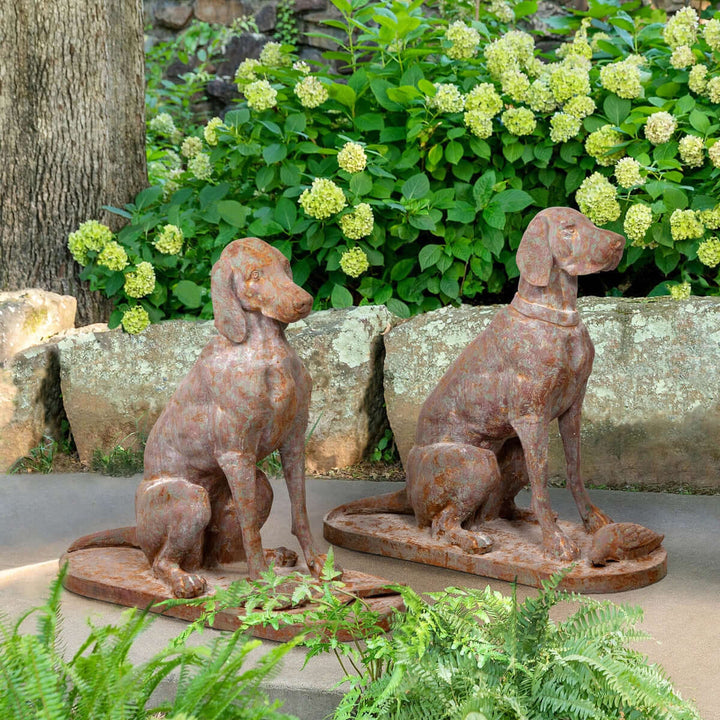 Rustic cast iron hunting dog sculptures in a garden setting, set of 2, evoking English country manor charm.