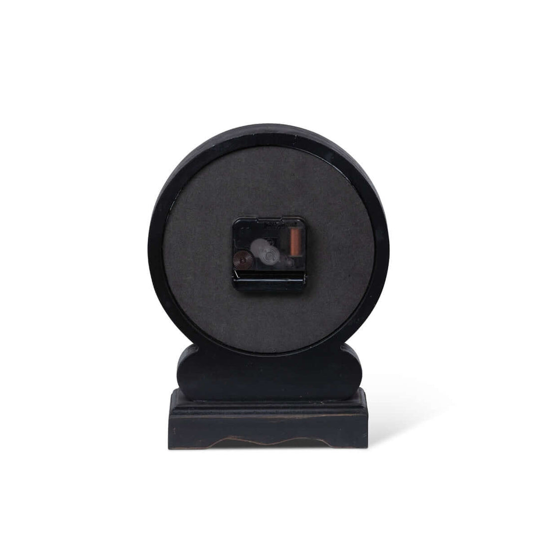 Back view of antique-style mantel clock with black finish and Roman numerals, showcasing its battery compartment.