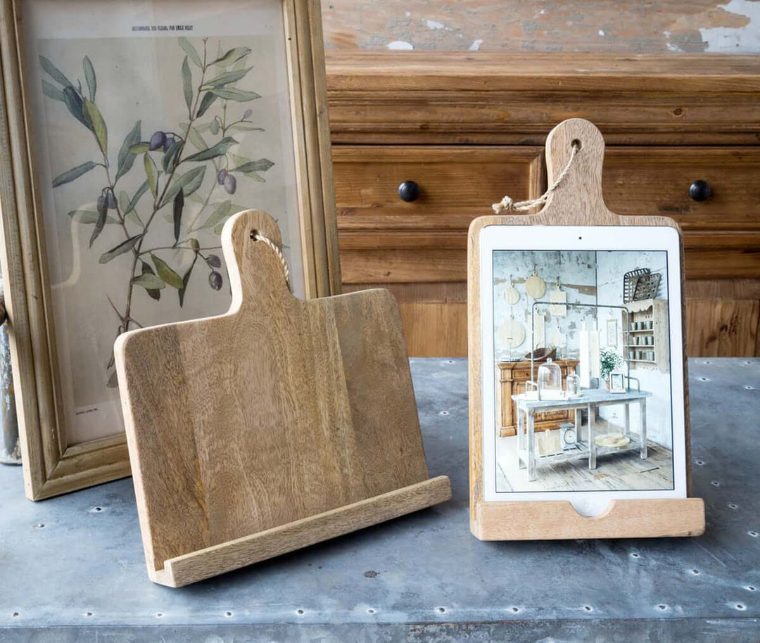 Wooden farmhouse cookbook holder resembling a cutting board, ideal for rustic kitchen decor, displaying a tablet, crafted from natural wood.