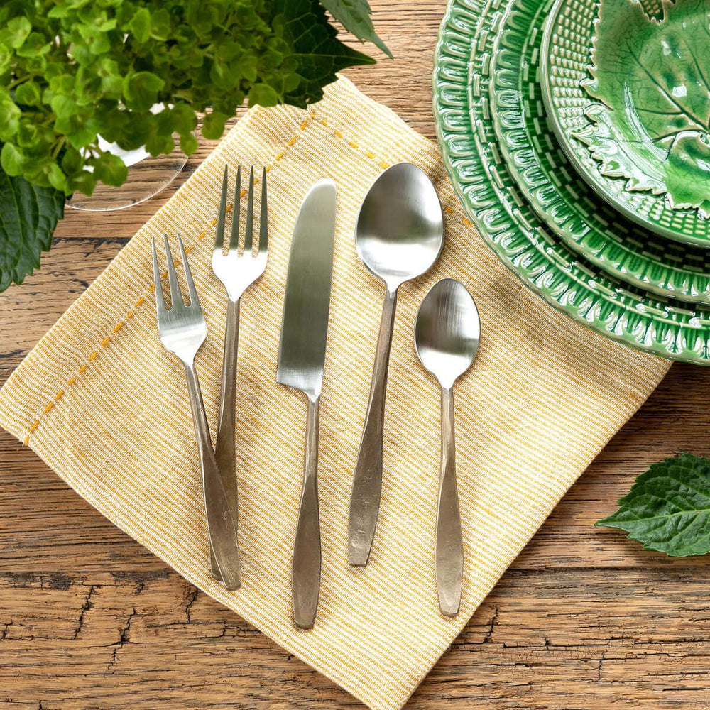 Hand-Forged Antique Gold Flatware Set with detailed fork, knife, spoon, elegantly displayed on a rustic table with vintage dishes.