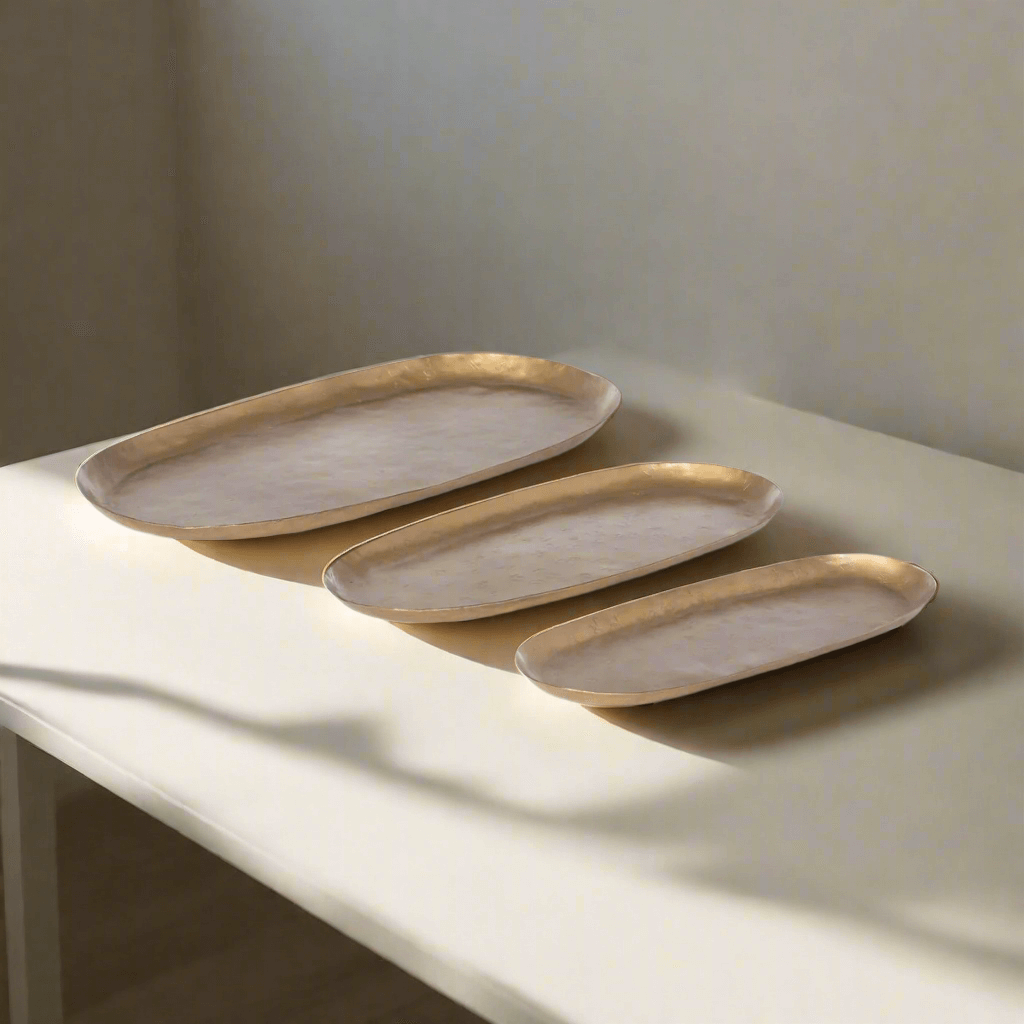 Vintage Gold Iron Serving Tray Set with three hand-hammered oval trays on table