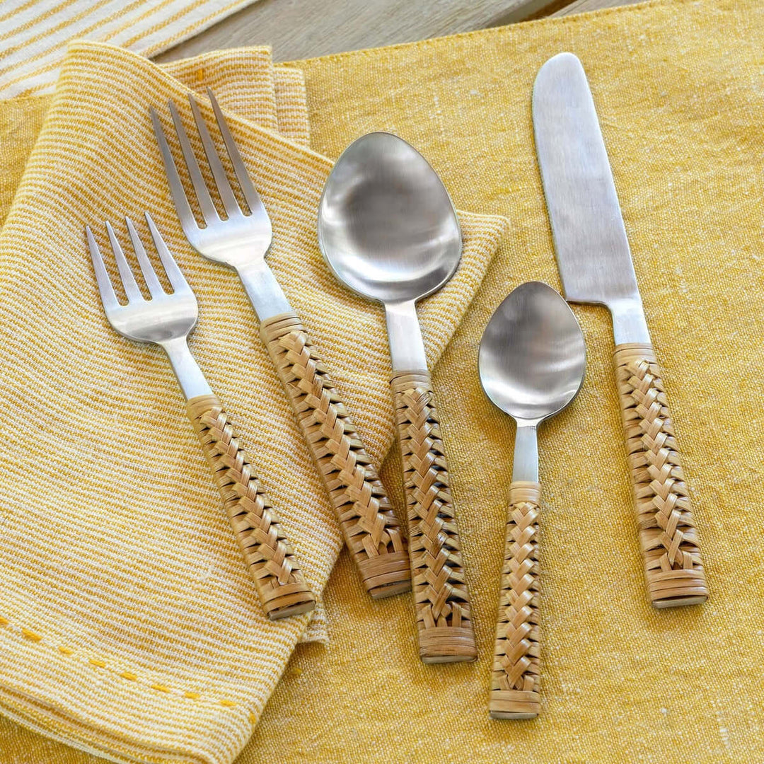 Handwoven bamboo and stainless steel cutlery set on yellow napkin, showcasing vintage-inspired artistry and natural materials.