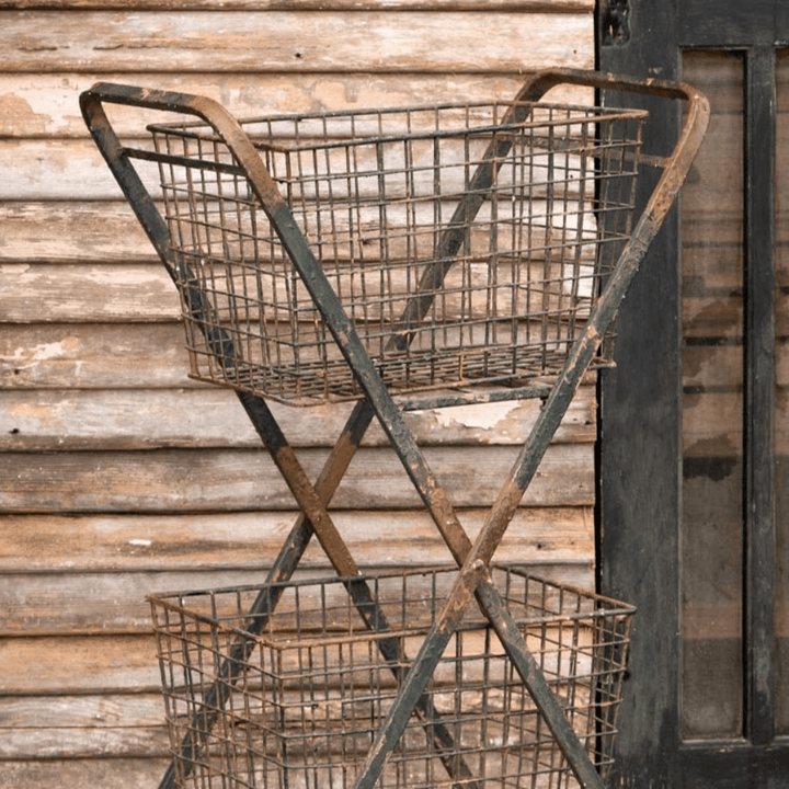 Vintage double basket metal market cart with rustic farmhouse charm against weathered wooden backdrop.