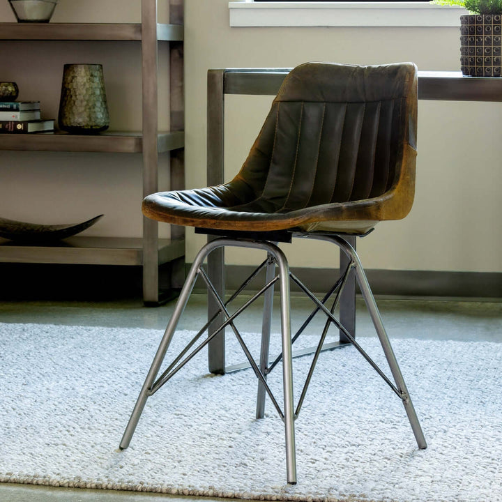 Vintage industrial desk chair with aged leather seat and metal legs in a stylish workspace setting.