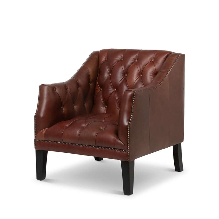 Tufted leather club chair in cordovan brown with nailhead trim, offering classic comfort and timeless design.