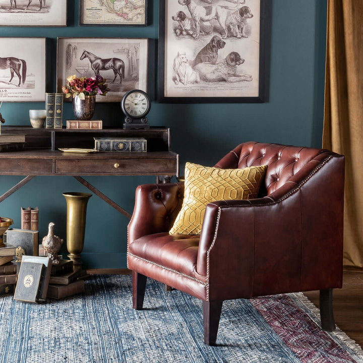 Tufted leather club chair in cordovan brown with nailhead trim, positioned in a vintage-inspired room, features rich, warm tones.