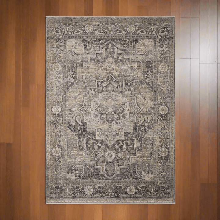 Traditional distressed loomed rug with vintage medallion design on wooden floor, evoking an antique and elegant aesthetic.