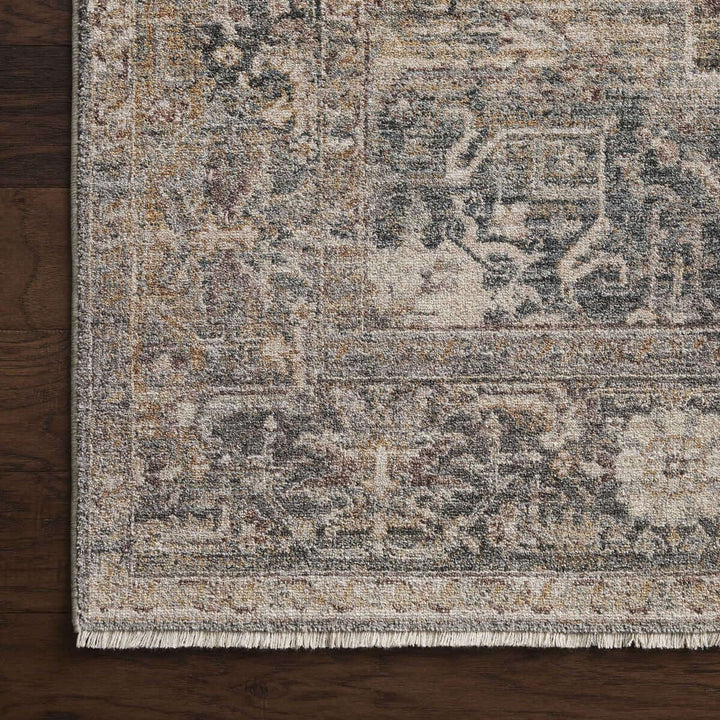 Traditional distressed loomed rug with vintage medallion and antique design on dark wood floor.