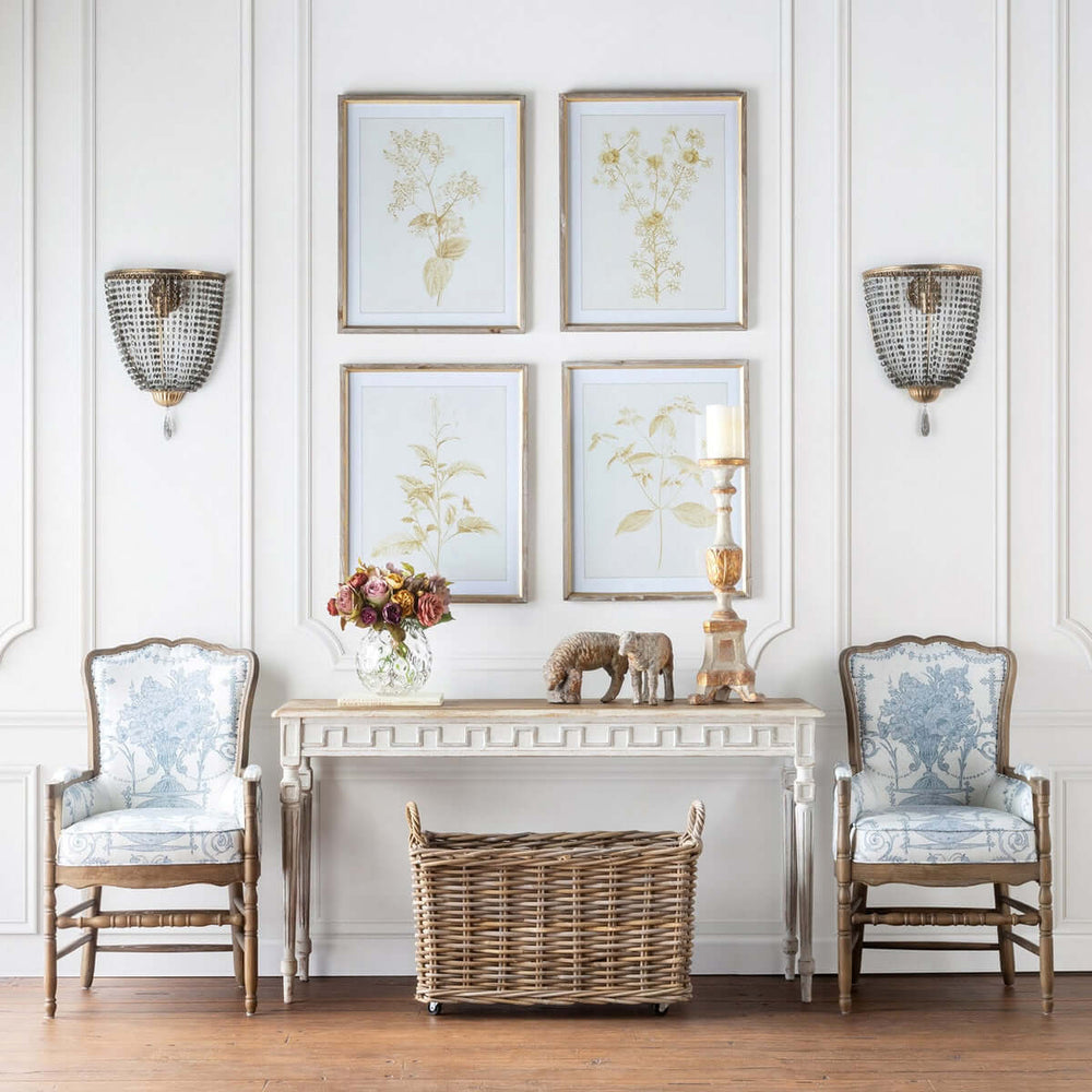 Luxury living room with antique gold crystal wall sconces, vintage chain shades, elegant chairs, and floral wall art.