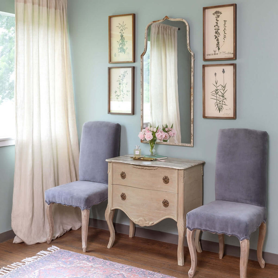 Elegant French Country arch mirror with distressed white frame in a vintage-inspired room, adding charm and sophistication.