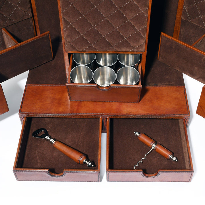 Brown leather bar case with silver cups and corkscrews on a white background