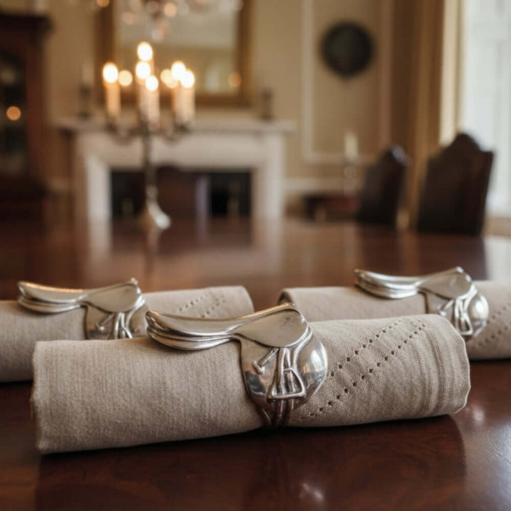 Silver saddle napkin ring on a beige napkin on a dining table