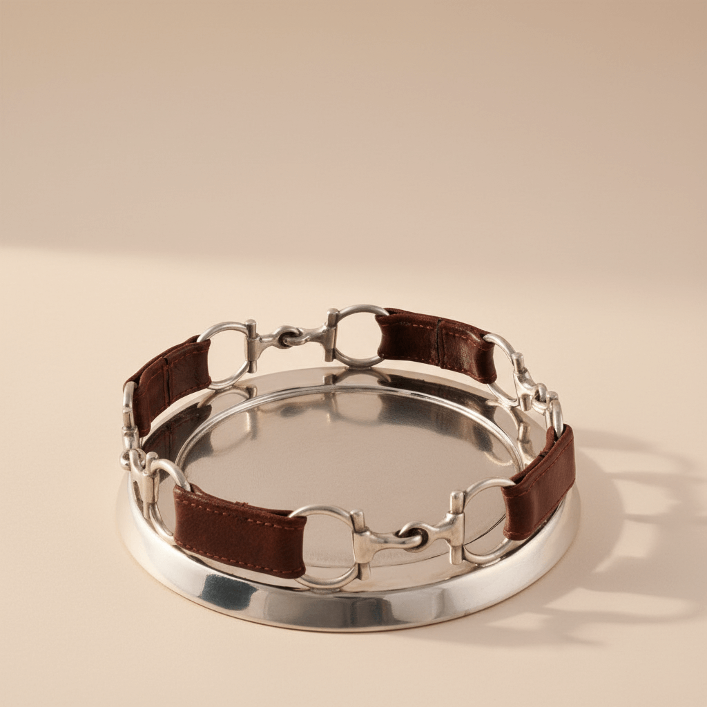 Silver horse bit with brown leather strap on a beige background