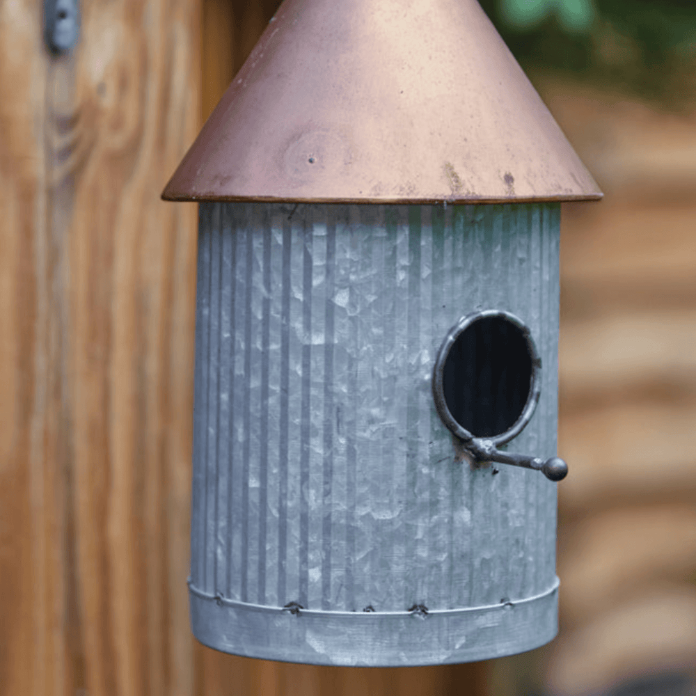 Farmhouse galvanized birdhouse with a copper roof, showcasing rustic elegance and timeless simplicity.