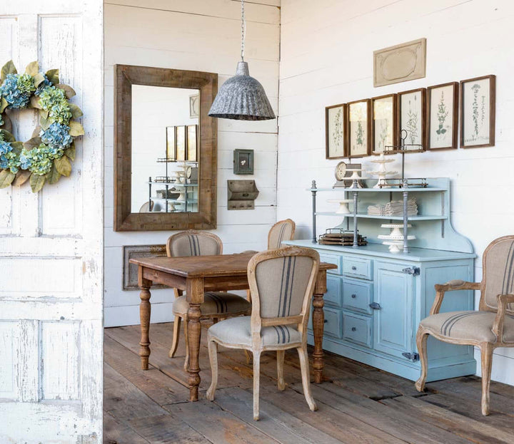 Dining room with wooden table and chairs, light blue cabinet, and decorative elements.