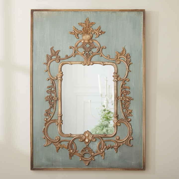 Decorative wall mirror with ornate gold frame on a light beige wall