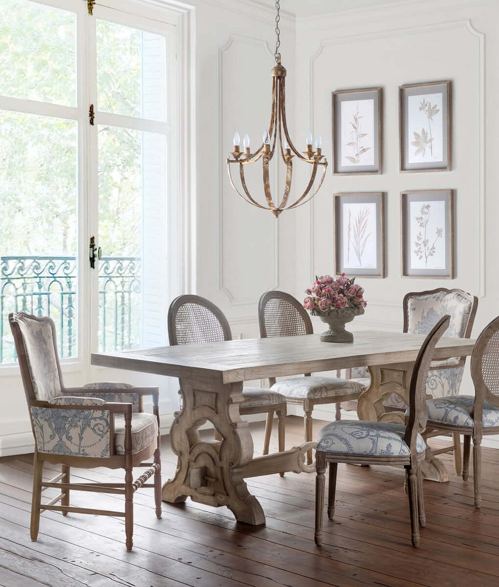 Dining room with wooden table and chairs, chandelier, and framed pictures on the wall.